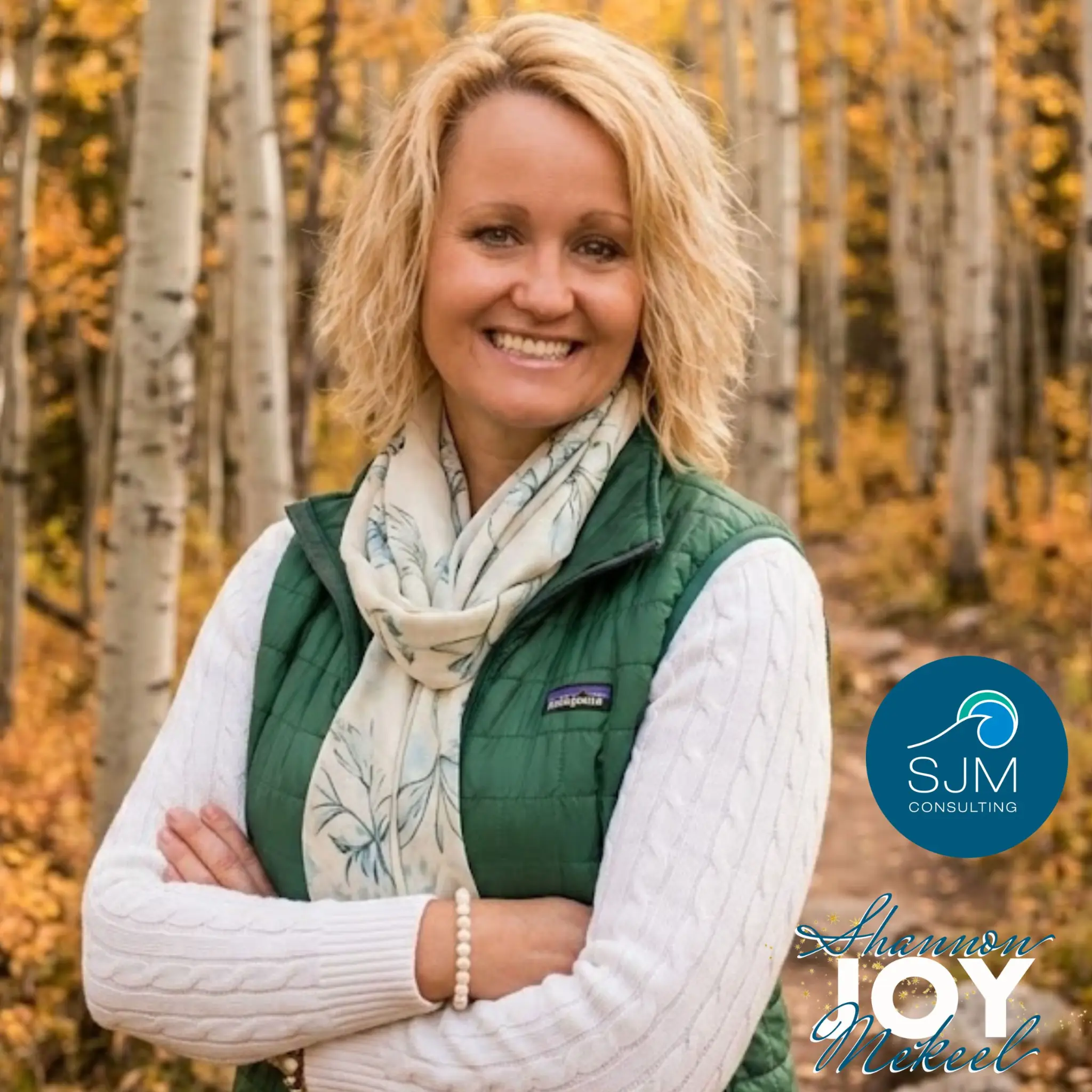 Shannon Joy Mekeel smiling outdoors among autumn aspens
